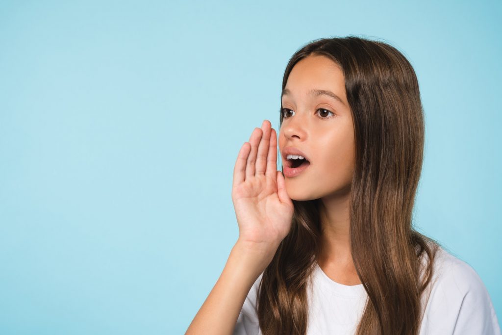 Pupil shouting using hand like loudspeaker announcing news secrets rumors isolated in background